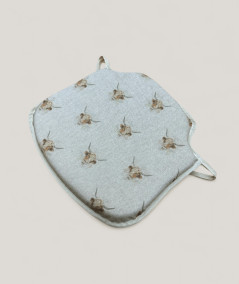 Spindle shaped chair pads in beige linen type fabric with a highland cow print