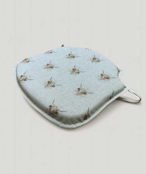 Spindle shaped seat cushions in beige linen type fabric with a highland cow print