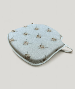 Spindle shaped seat cushions in beige linen type fabric with a highland cow print