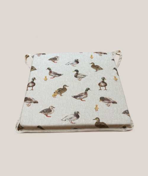 Square shaped non-slip chair pads in beige with a modern duck design