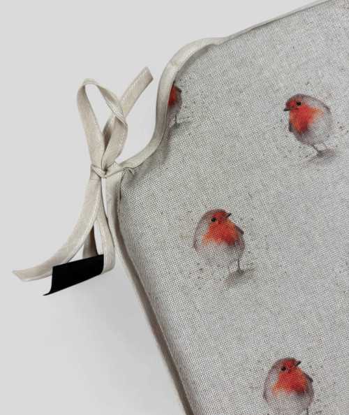 Beige spindle shaped non-slip chair pads with a red robin print