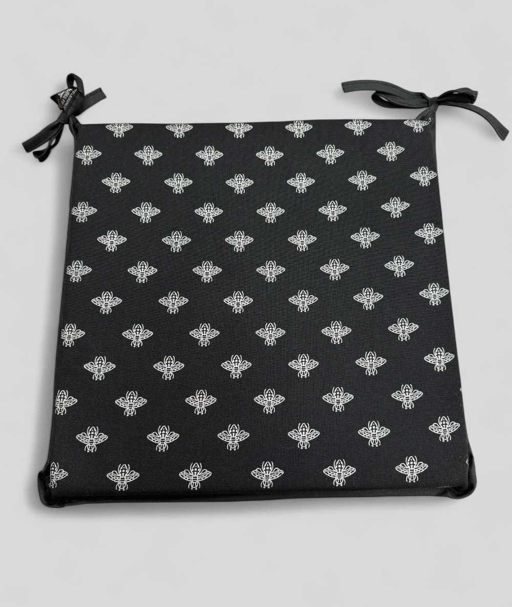 Square shaped black seat pads with a small bee metallic print