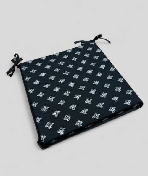 Square shaped black chair cushions with a small bee metallic print
