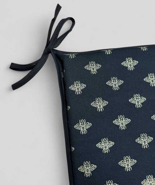 Black square shaped chair pads with an all over small gold bee print