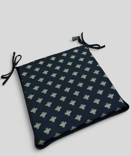 Black square shaped chair cushions with an all over small gold bee print