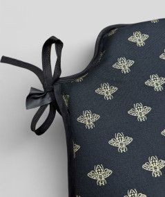 Black spindle shaped chair pads with an all over small gold bee print