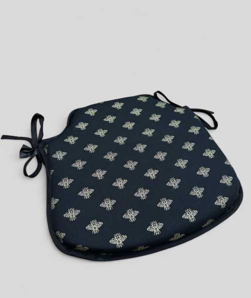 Black spindle shaped chair cushion with an all over small gold bee print