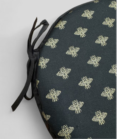 Black circular bistro chair pads with an all over small gold bee print