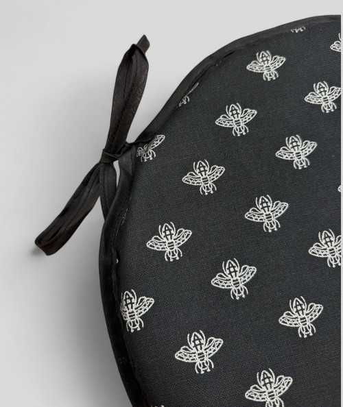 Round black chair pads with an all over small silver bee design