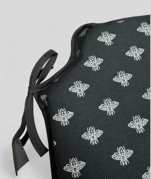 Black spindle shaped chair pads with a small silver bee design