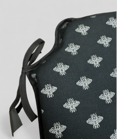 Black spindle shaped chair pads with a small silver bee design